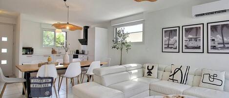 Una sala de estar moderna con sofá, mesa de centro y comedor.