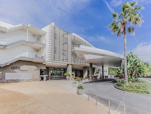 A modern hotel with a flat roof, a covered entrance, and a palm tree. - Cotton Beach 119 with Private Roof Top (Tweed)