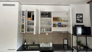 A modern kitchen with white cabinets, a black countertop, and a built-in oven. - Haus Petunia by Interhome (Saas-Grund)