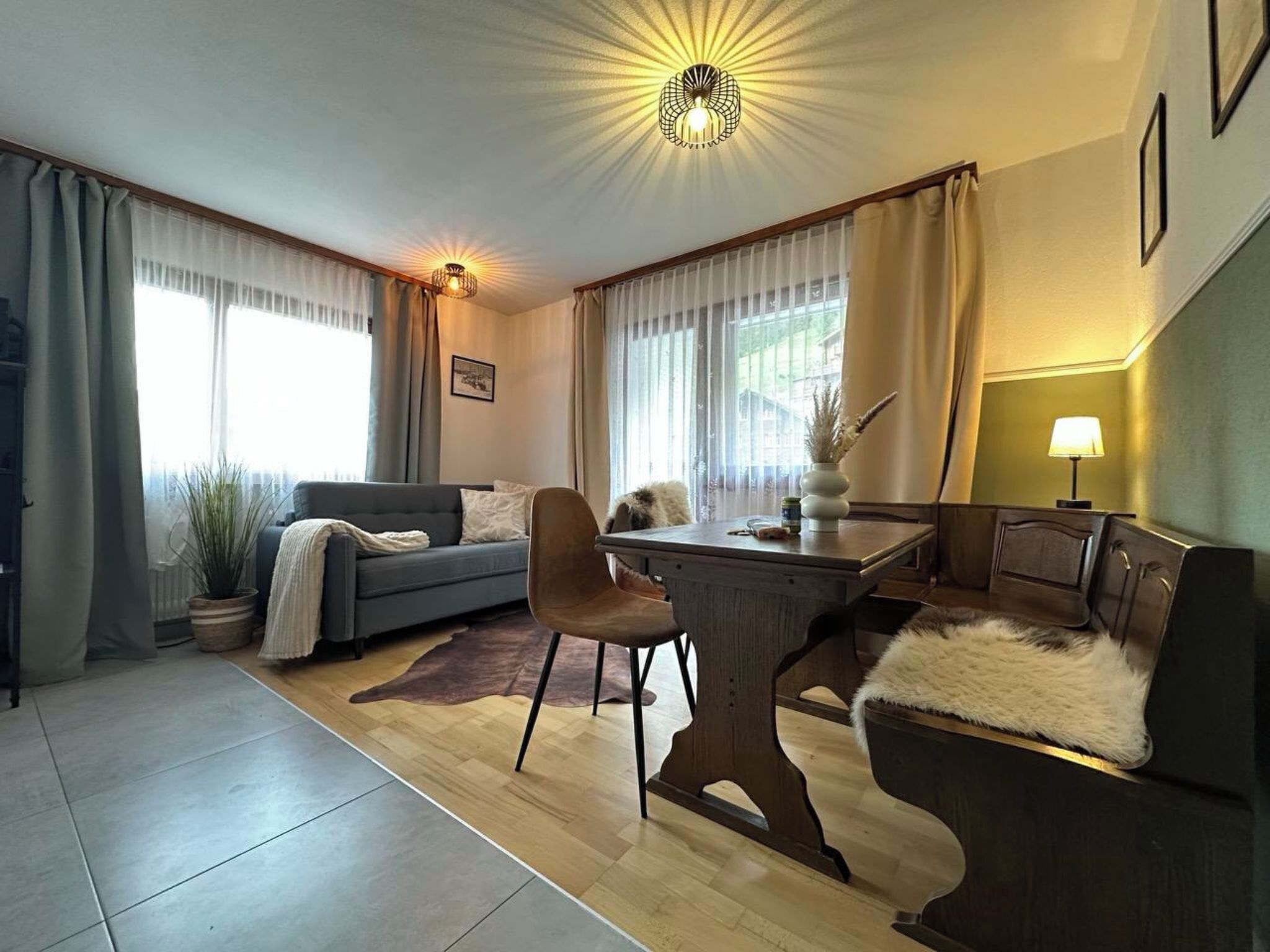 Ein modernes Wohnzimmer mit einer Couch, einem Esstisch und einer Lampe.