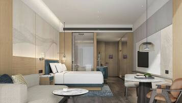 A modern hotel room with a bed, seating area, and a small table.