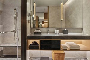 A modern bathroom with a glass shower enclosure, a vanity with a mirror, and a towel rack.