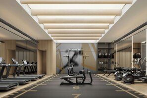 Un gimnasio moderno con cintas de correr, máquinas de pesas y pesas sueltas.