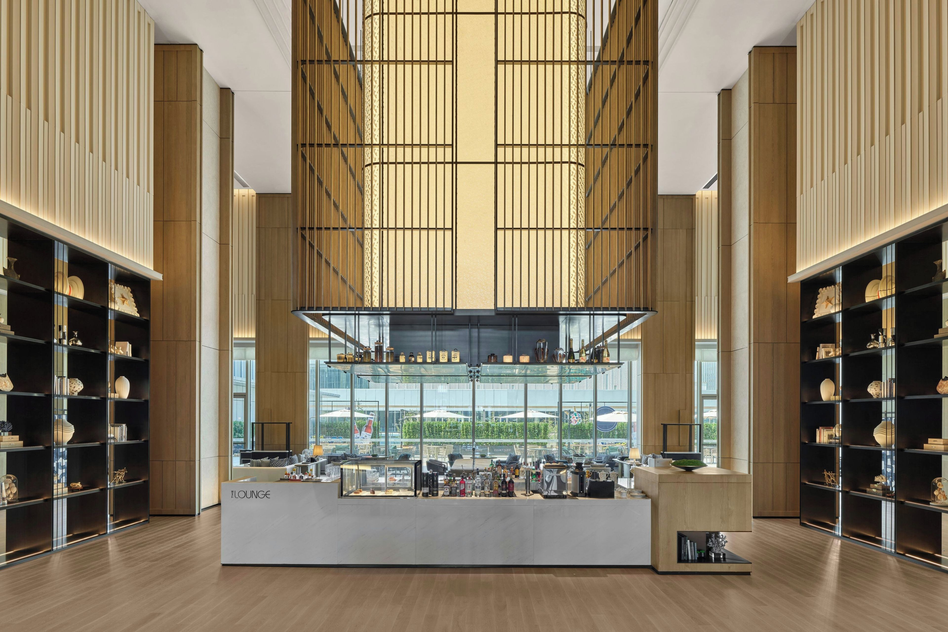 Un amplio salón con barra central, techos altos y grandes ventanales que ofrecen vistas al exterior.