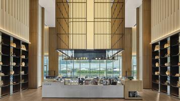 Un amplio salón con barra central, techos altos y grandes ventanales que ofrecen vistas al exterior.