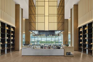 Un amplio salón con barra central, techos altos y grandes ventanales que ofrecen vistas al exterior.