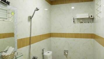 Une salle de bain avec un lavabo, des toilettes et une douche.