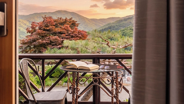 A balcony with a table, a chair, and an open book.