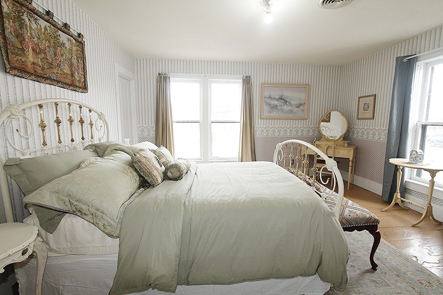 A bedroom with a bed, a dresser, a chair, and a table.