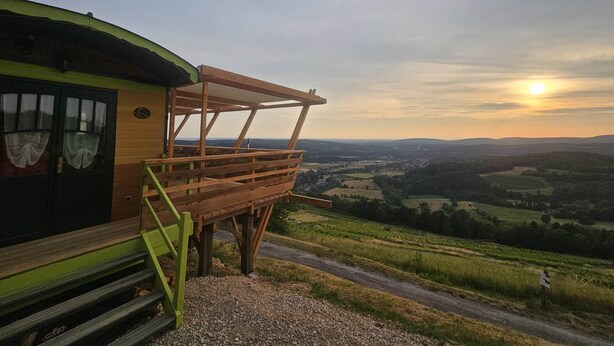 A rustic wooden building with a wooden deck and steps leading to a door. - Unusual caravan, sunset with vineyards in the Ain valley (SAINT-ALBAN)