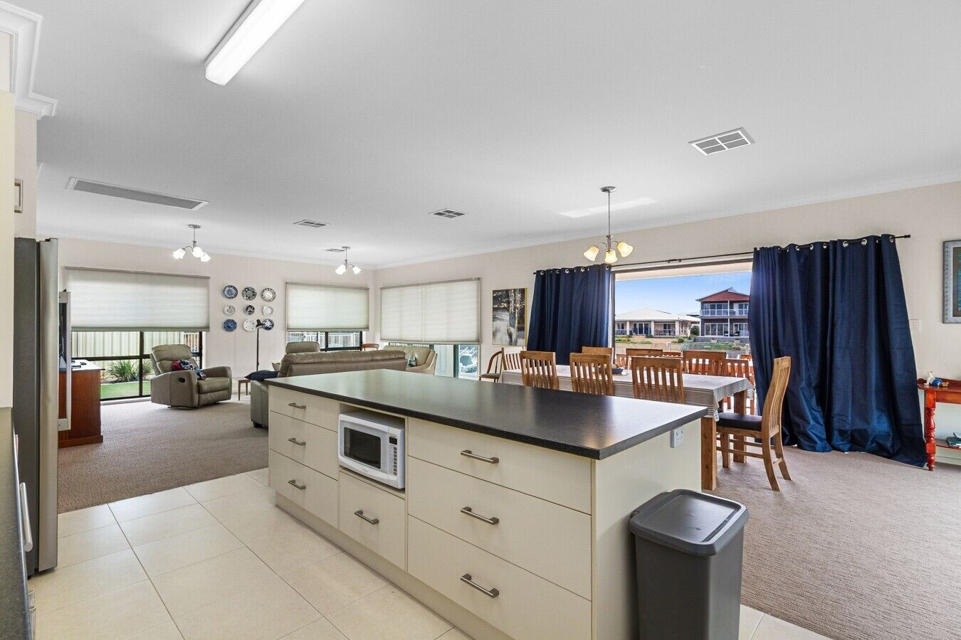 A spacious kitchen with a dining area, large windows, and a view of the outside.