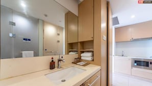 Ein modernes Badezimmer mit Waschbecken, Spiegel und Holzschränken.