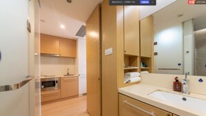 Eine moderne Küche mit Holzausstattung, einer Mikrowelle und einem Spülbecken.