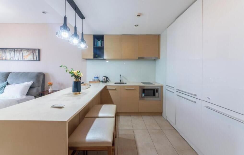 Una cocina moderna con una isla central, electrodomésticos integrados y un comedor con banco.