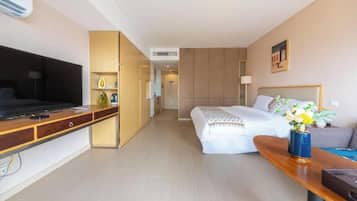 A hotel room with a bed, a desk, a television, and a wardrobe.