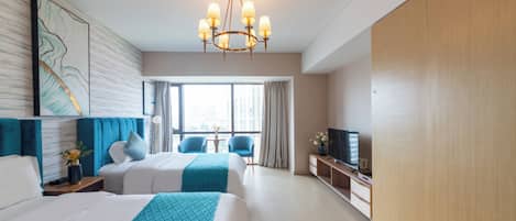 A hotel room with two beds, a TV, a desk, and a large window.