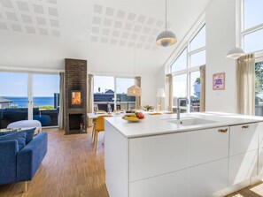 A modern kitchen with a large island, a fireplace, and a view of the sea. - "Andriette" - 50m from the sea by Interhome (Haderslev)