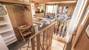 A wooden interior with a staircase, a sofa, and a kitchen area. - Chalet Agathli, (Flumserberg Bergheim), by Interhome (Flumserberg Bergheim)
