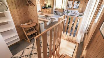 Un intérieur en bois avec un escalier, un canapé et un coin cuisine.