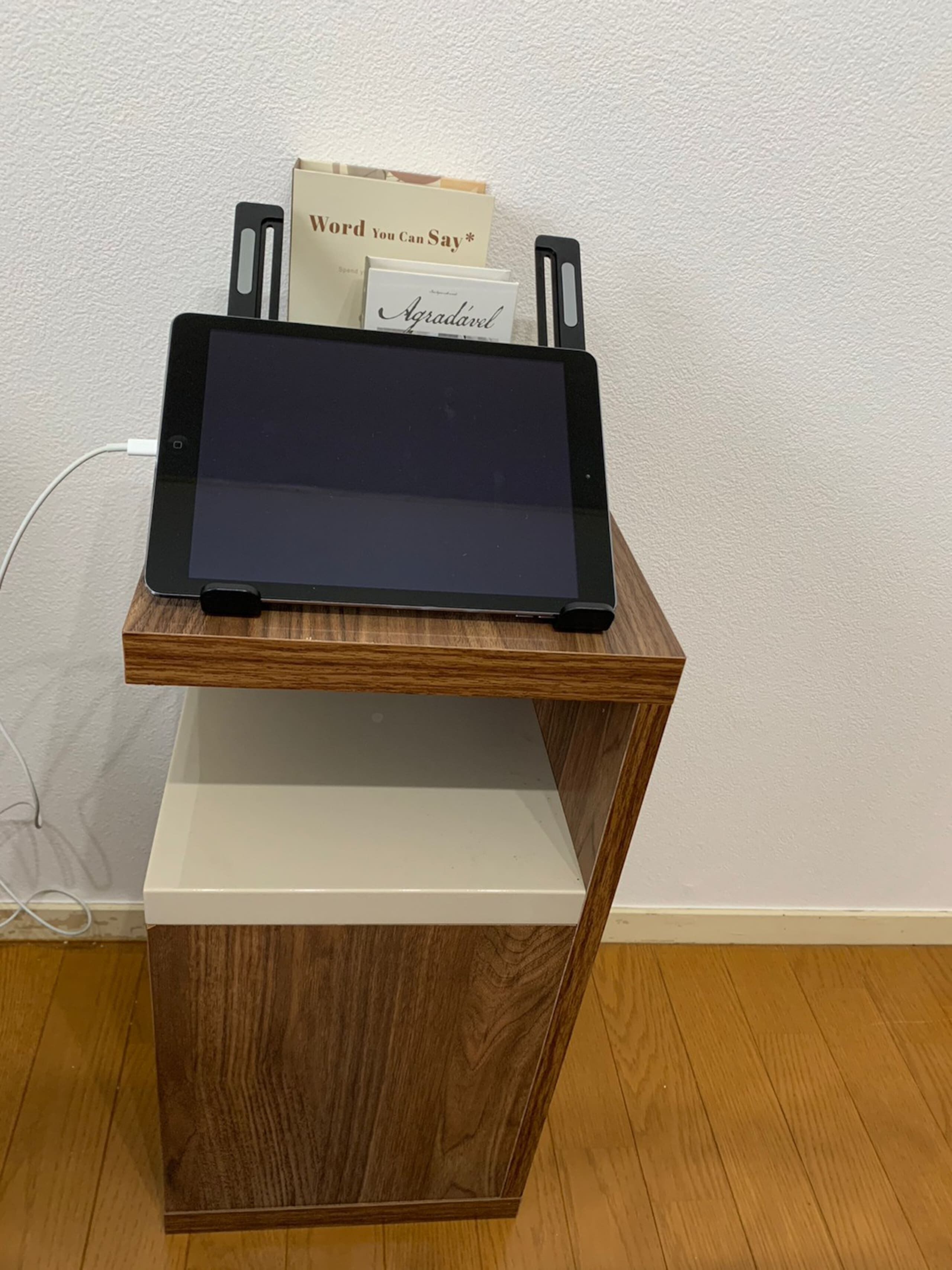 Un escritorio de madera con una tableta y libros.