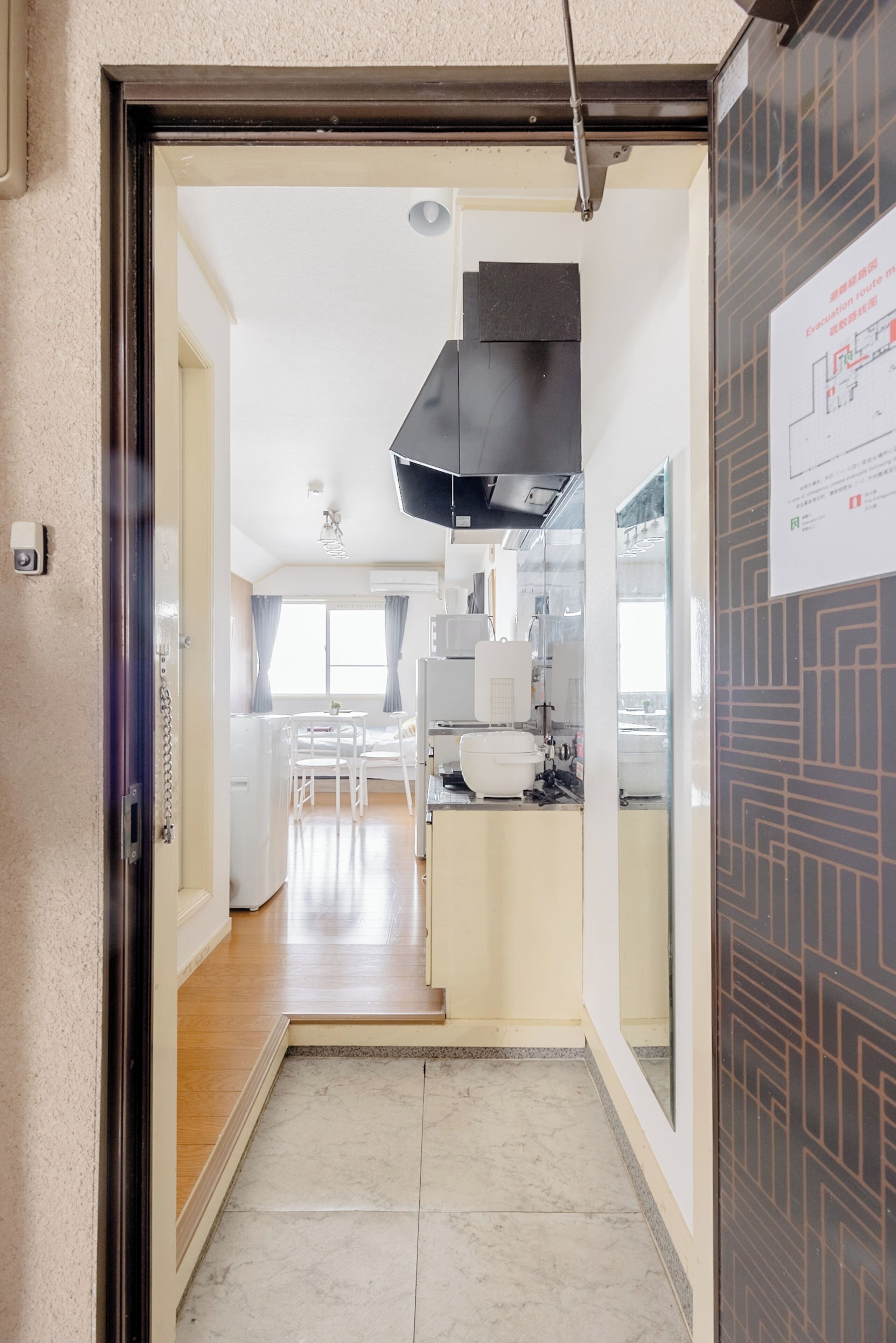 Un couloir mène à une cuisine au design moderne, à un coin repas et à un ventilateur de plafond bien visible.