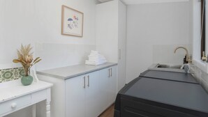 A compact kitchen with white cabinets, a sink, and a countertop.