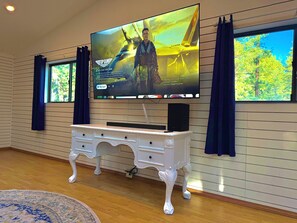 A television mounted on a wall with a wooden cabinet below it.