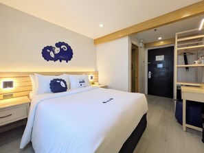 Quarto de hotel com uma cama grande, mesas de cabeceira, um guarda-roupa e uma obra de arte na parede.