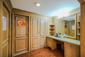 A hotel bathroom with wooden cabinetry, a large mirror, and a herringbone-patterned floor. - CASA Sukhumvit 39 (Bangkok)