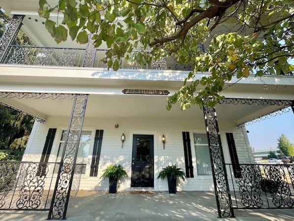 A two-story house with a porch, black shutters, and a street sign reading '427 THIRD ST.'