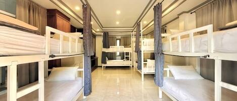 A corridor with bunk beds, a kitchenette, and a bathroom.