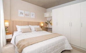 Ein Schlafzimmer mit Bett, Nachttischlampen, einem Nachttisch, einem Kleiderschrank und Wandbildern.
