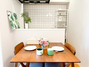 Ein Esstisch mit Tellern, einer Tasse und einem Korb voller Blumen.