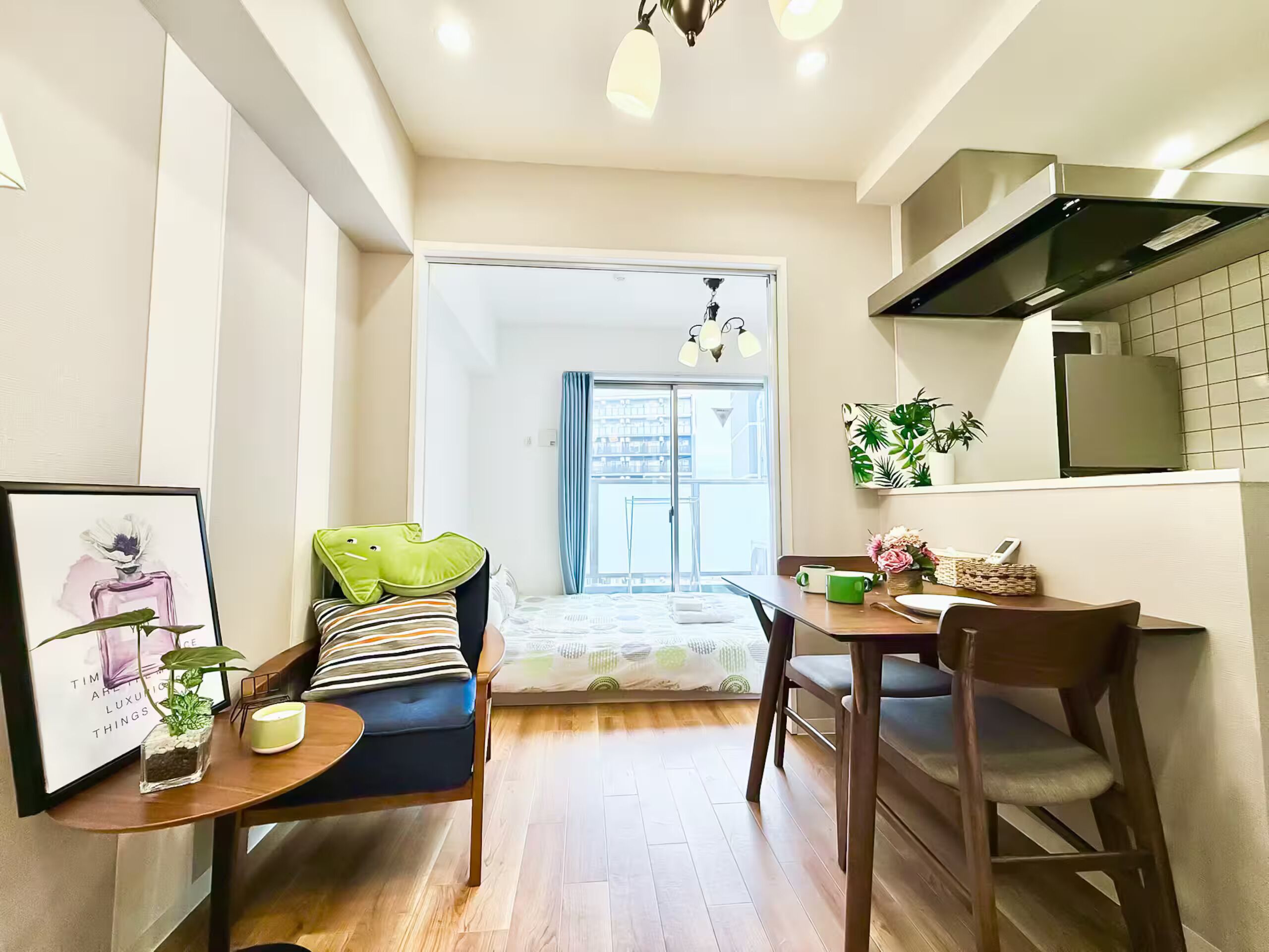A compact living space with a kitchenette, a dining area, and a bed with a view.