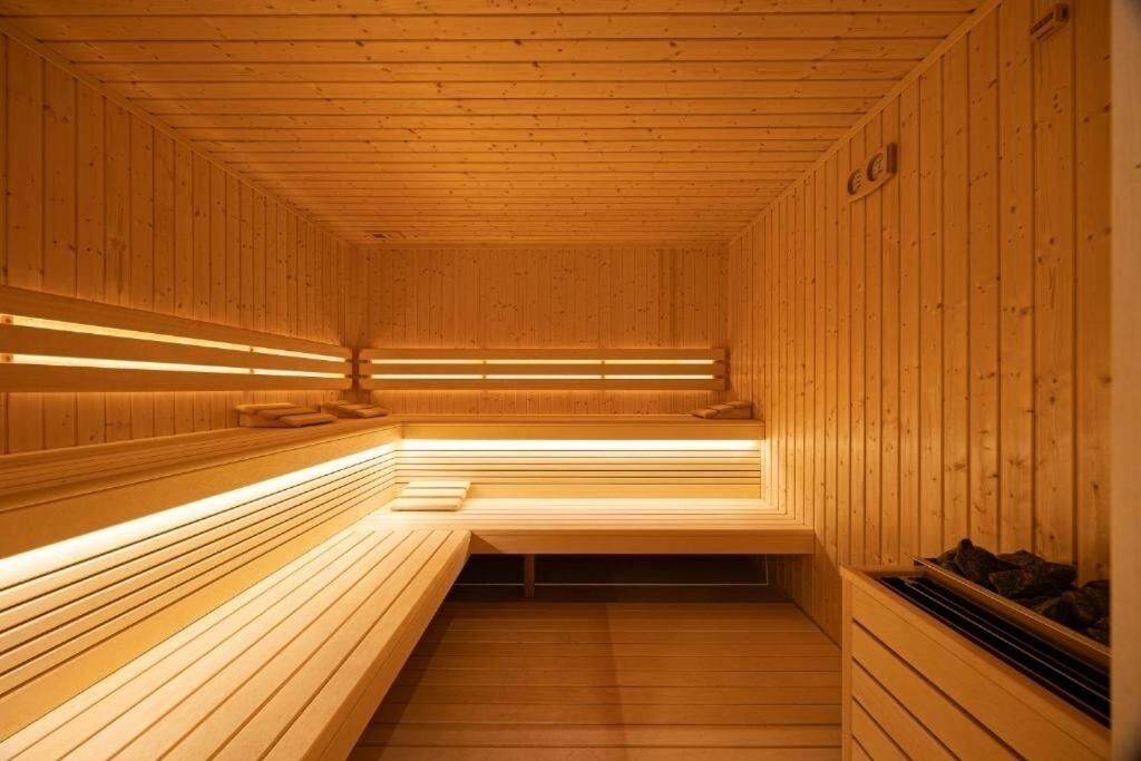 Un sauna avec des bancs en bois, des murs en bois et un plafond avec des poutres en bois.