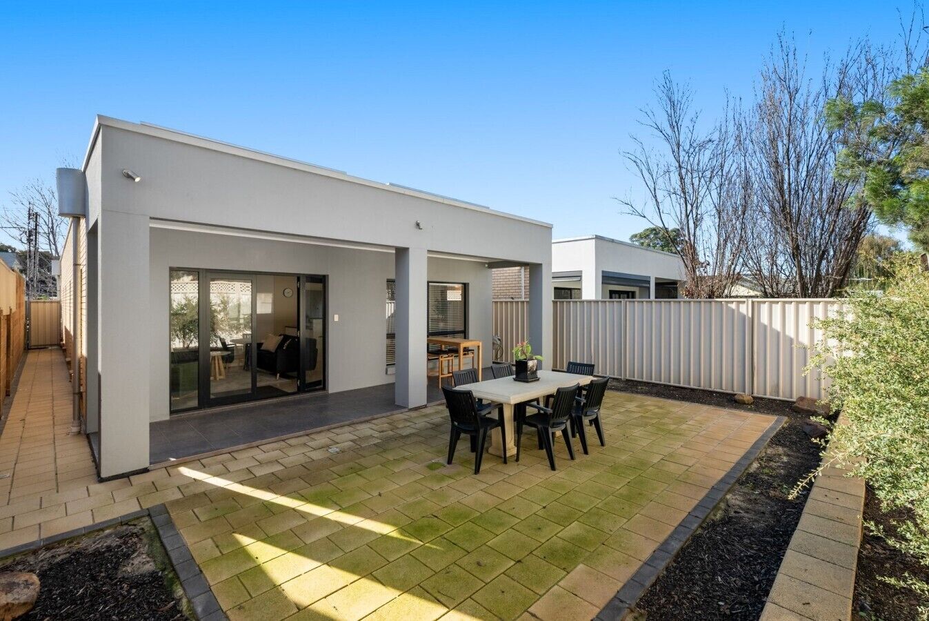 Et moderne hus med terrasse, spiseområde og garage.