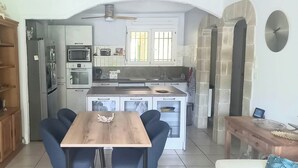 Eine kompakte Küche mit Essbereich, Deckenventilator und Topfpflanze.