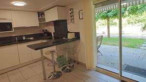 A kitchen with a dining area, a coffee machine, and a view of the outdoors. - Just 9 minutes from Bordeaux: a getaway along the Garonne River at the 4-star Latresne vacation rental (Latresne)