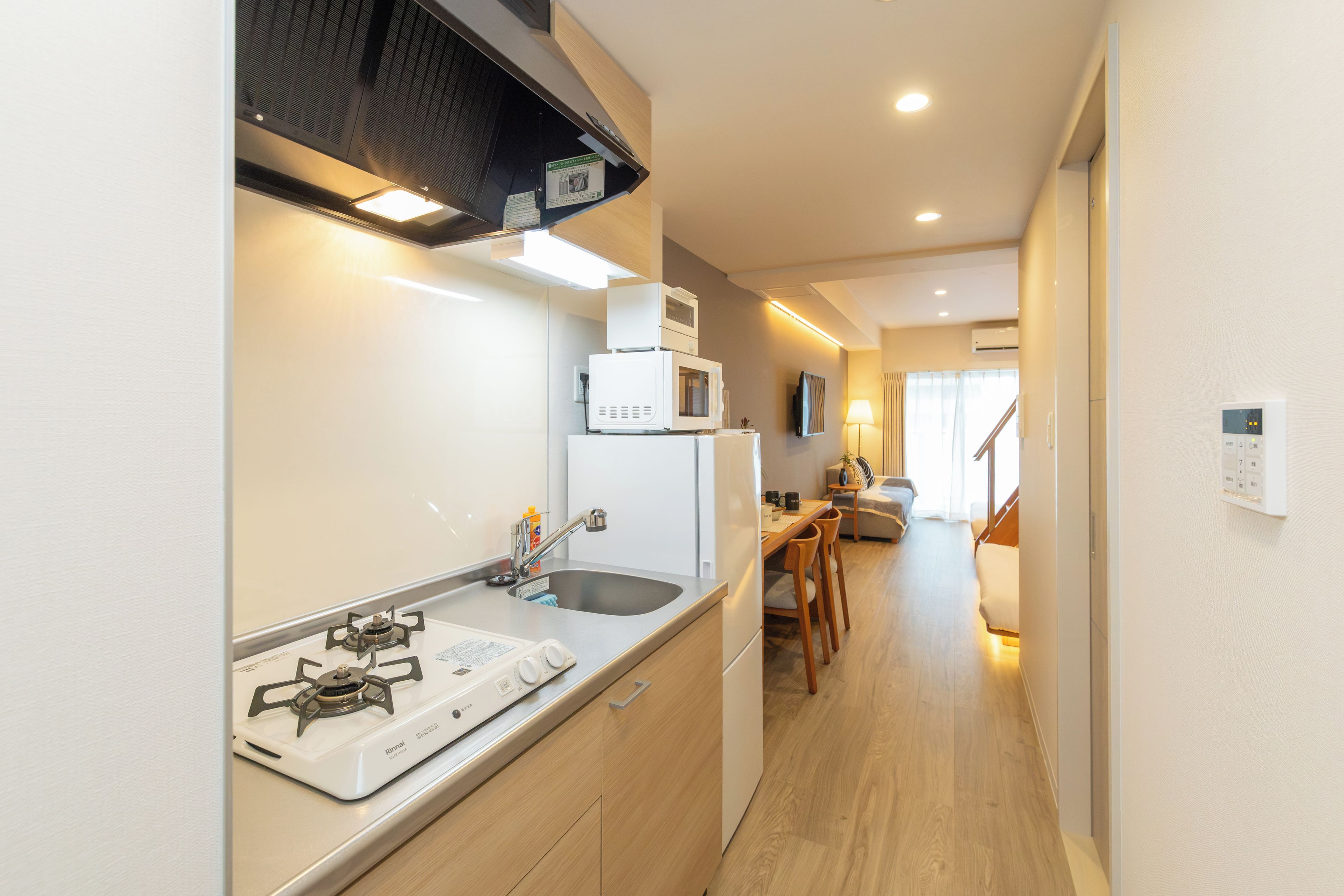 A compact kitchen with a gas stove, microwave, and a small dining area with a table and chairs.