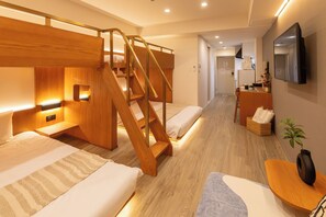 A hotel room with a bunk bed, a desk with a chair, a flat-screen TV mounted on the wall, and a small potted plant. - NOVI Dotonbori  (CHUO-KU OSAKA)