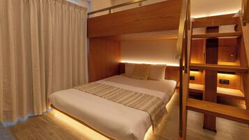 A bunk bed room with a wooden ladder, a bedside table, and a curtain.