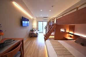 A modern hotel room with a wooden staircase, a flat-screen TV, a sofa, and a dining area with a table and chairs. - NOVI Dotonbori  (CHUO-KU OSAKA)
