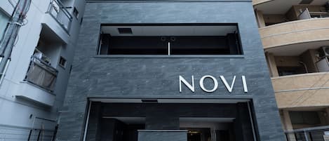 A modern building with a prominent 'NOVI' sign at the entrance.