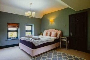 Une chambre à coucher avec un lit, un lustre, une table de chevet et une porte.