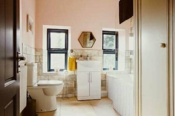 Une petite salle de bain comprenant des toilettes, un lavabo et un meuble de rangement.