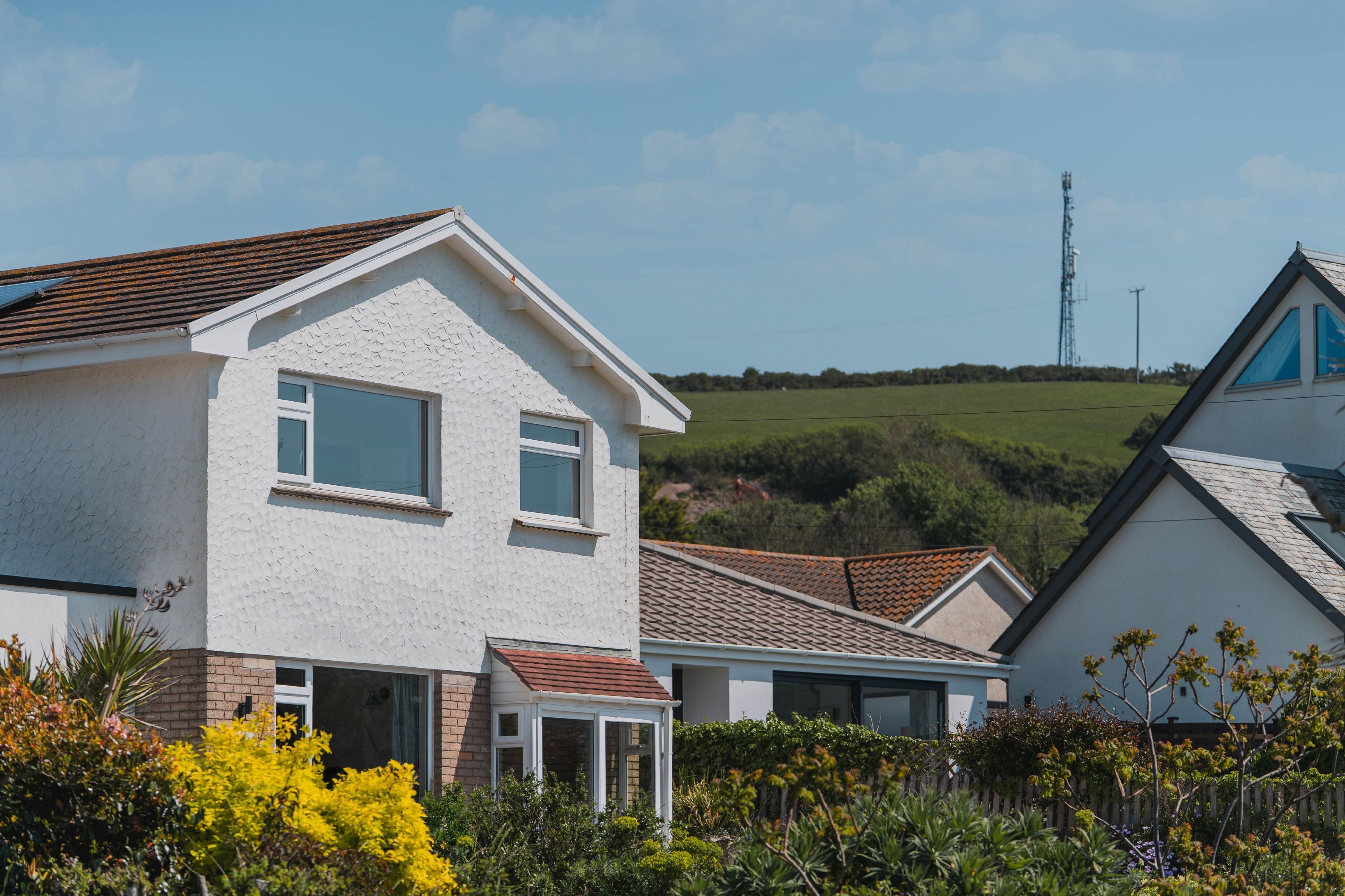 A residential area with houses featuring pitched roofs and white exteriors.