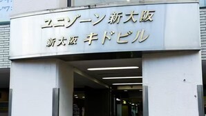 Ein Gebäudeeingang mit einem Schild in japanischer Schrift.