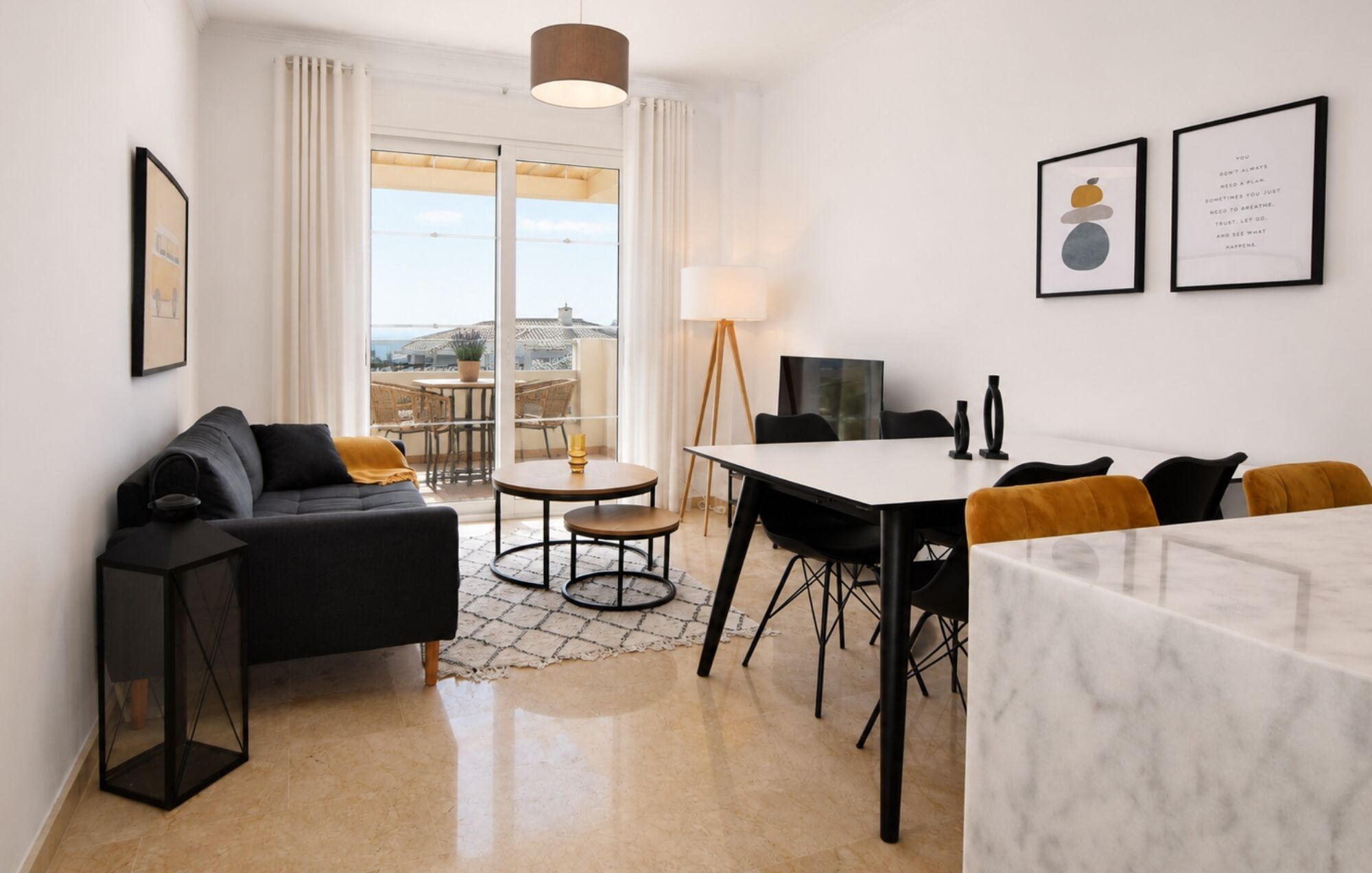 Ein modernes Wohnzimmer mit einer Couch, einem Esstisch und einem Fernseher.
