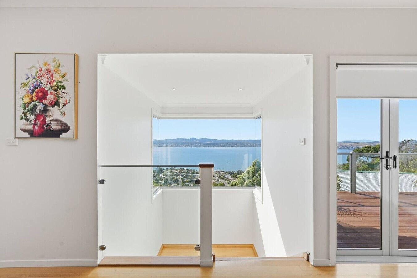 A modern interior with a clear view of the sea through a glass door.