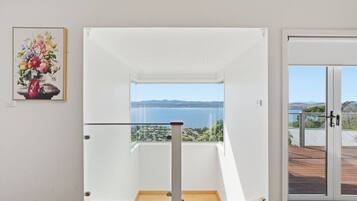 A modern interior with a clear view of the sea through a glass door.